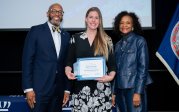 Stephanie Smaglo holds award while posing for picture with ODU President Brian O. Hemphill.