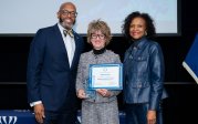 Sylvia Ameen holds award while posing for picture with ODU President Brian O. Hemphill.