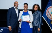 Victoria Martin holds award while posing for picture with ODU President Brian O. Hemphill.
