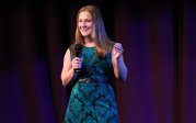 A woman speaks on a stage. 