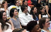 Graduates smiling in crowd. 