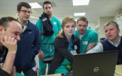 EM residents gathered around Dr. Knapp at a laptop
