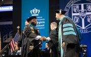A student shakes hands with someone.