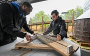 Two students work together on an oyster cage.