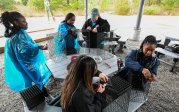 A group of students and staff work together on oyster cages.