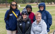 A group of people pose for a photo on a golf course. 