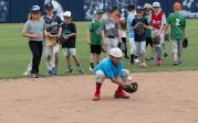 A young baseball player fields the ball.