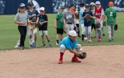 A young baseball player fields the ball.