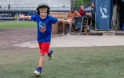 A young baseball player rounds the bases after hitting a home run. 
