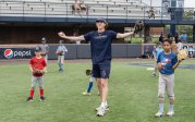 A baseball coach celebrates a good play made by his young athletes.