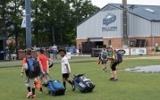 Young players gather their equipment and leave the field.