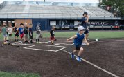 A young baseball player runs to first base.