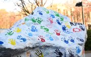 Students return to campus after Spring Break and pay tribute to Lt. Col. Brandon Shah (B.S. ’07) with painted handprints and messages of condolences on Dominion Rock.
