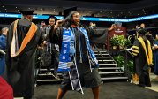 A student dances after walkign across the stage at commencement.