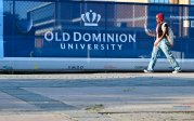 A student walks by a construction fence on ODU's campus.