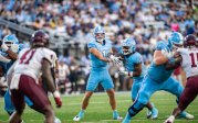 Colton Joseph hands the ball to running back Maurki James during a football game.