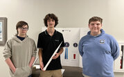 HERMES team – Jackson, Remi, and David with their research poster and rocket.