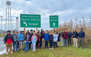 AAES students standing in front of International Space Station road sign.