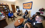 A group of students talk with a state delegate in their office.