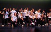 Monarchs Move participants and volunteers pose for a group photo on stage at their spring recital.