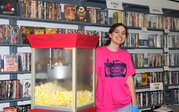 person standing next to a popcorn maker