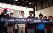 AAES students standing behind a ribbon at a ribbon cutting ceremony.