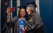 Students take a selfie to congratulate each other after receiving their diplomas. 