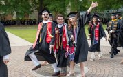 Graduating students walk across the University Seal