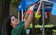 A student hangs a flag at ODU's student organization fair.