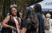 A student smiles at the camera while standing on Kaufman Mall on ODU's campus.
