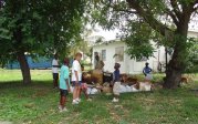 A group standing in a yard with containers of supplies.