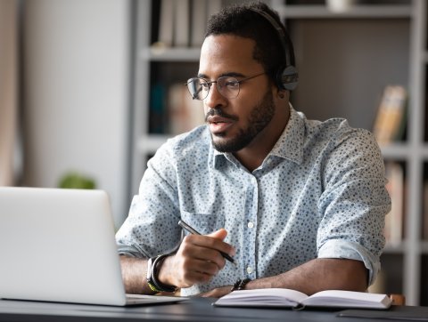 Focused businessman wear headphones study online watching webinar