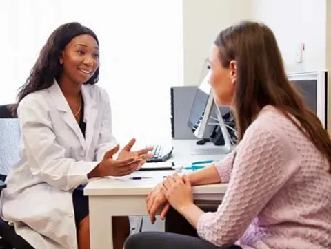 A physician talks with a clinical trial participant.
