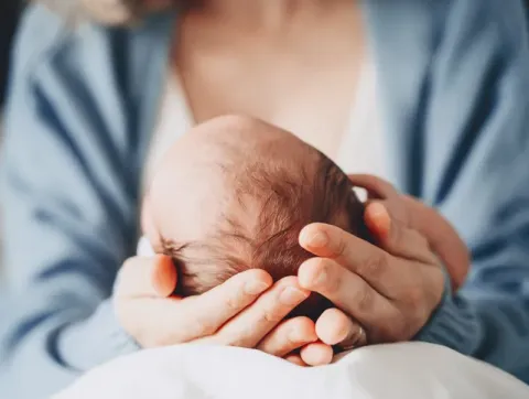 Newborn in mother's hands.