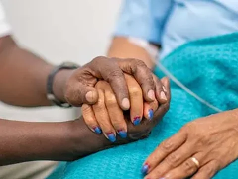Elderly woman is comforted by a medical professional. Focus 