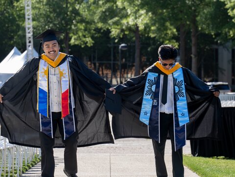 Two students showing their stole decorations