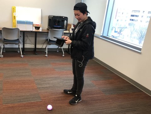 Student uses Sphero robot.