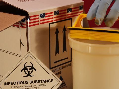 A Gloved Hand Opening A Biohazard Container