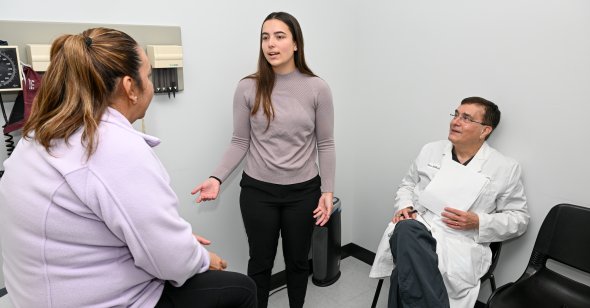 A woman talks to a patient in a doctor's office.