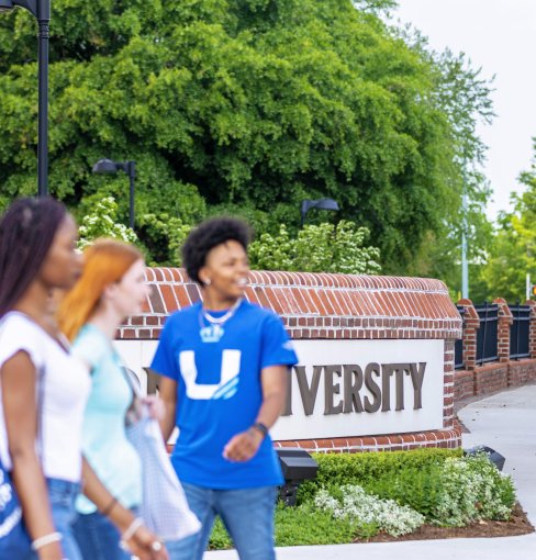 Groups of students walking in front of the education building