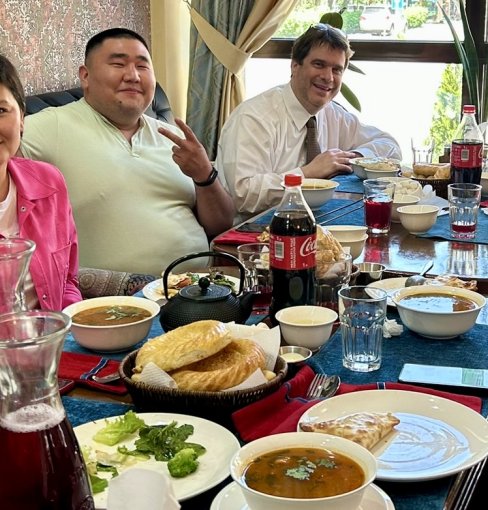 ODU professor Jim Blando, Ph.D., sits with other people at a table eating lunch 