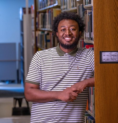 Jerome Newsome stands by library shelf