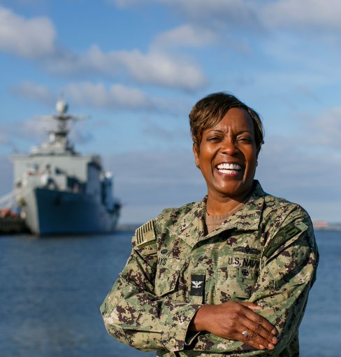 a woman stands outside near water 