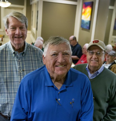 ODU alumni David Willett ’74, Jim Witcher ’75  and Billy Goodson Jr. ’71 stand in a restaurant. 