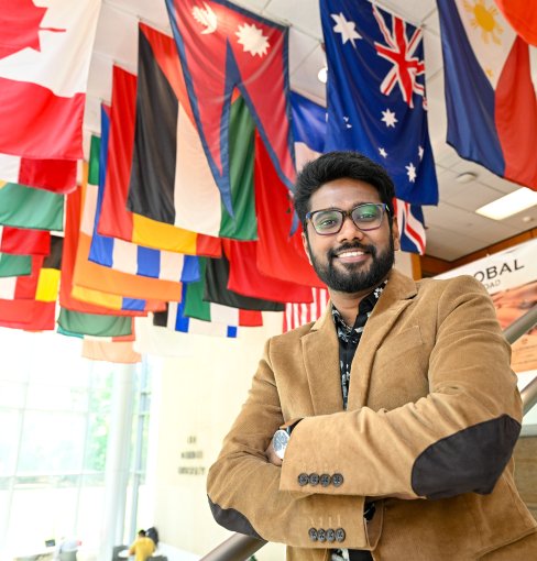 Man stands in front of flags