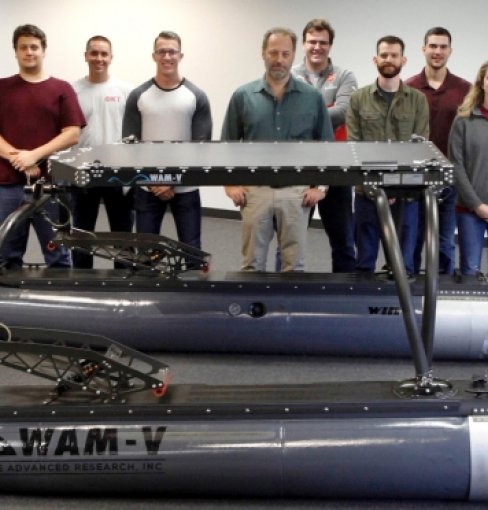 ODU BCET student stand behind unmanned naval surface vehicle