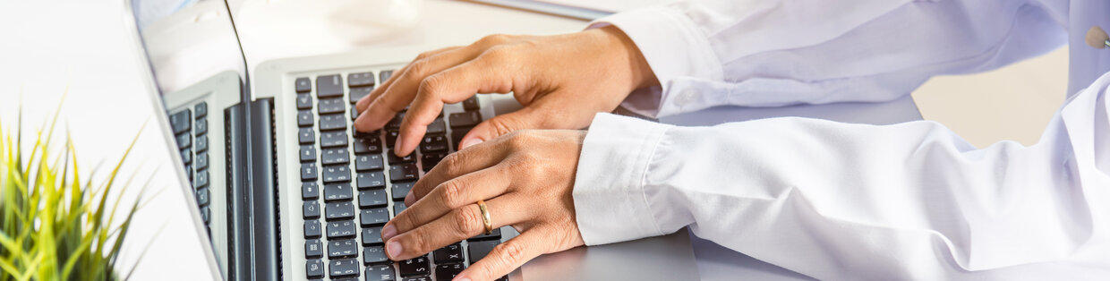 Dental professional in uniform on laptop