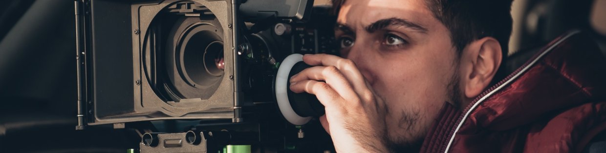 Person looking through a camera lens. 