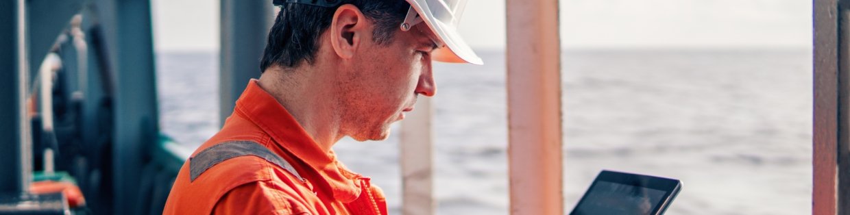A construction worker looking at a tablet.