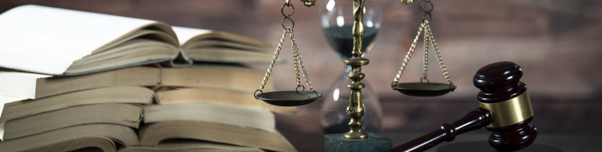 Justice scale in front of a pile of open books.